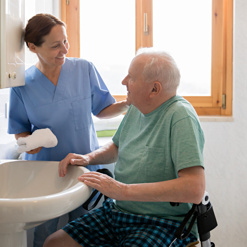 Home Caregiver with senior man in bathroom